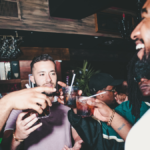 Young consumers drinking cocktails in a bar