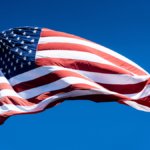 US flag on blue sky background