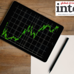 Graph on a tablet resting on a desk next to a blank sheet of paer