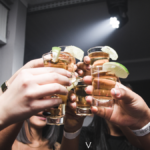 Consumers in a bar toasting with Tequila