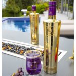 Au Vodka Black Grape bottle by a swimming pool
