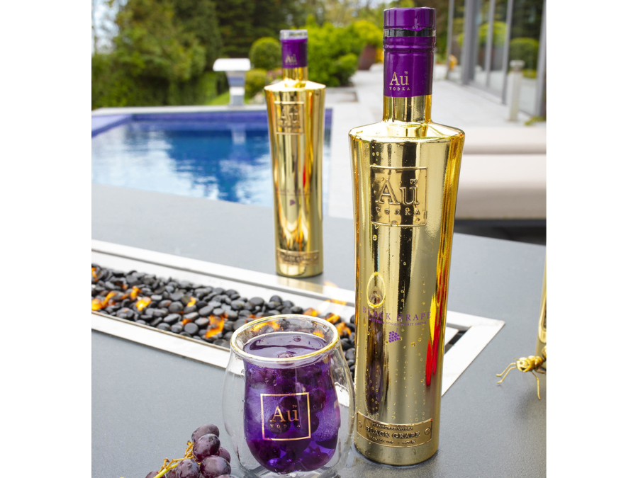 Au Vodka Black Grape bottle by a swimming pool