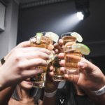 Consumers in a bar toasting with Tequila