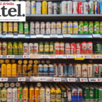 Beer cans on shelf display in supermarket
