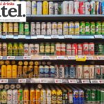 Beer cans on shelf display in supermarket