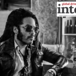 Lenny Kravitz at a bar with a bottle of new sotol brand Nocheluna