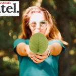 Woman holding a leaf towards the camera