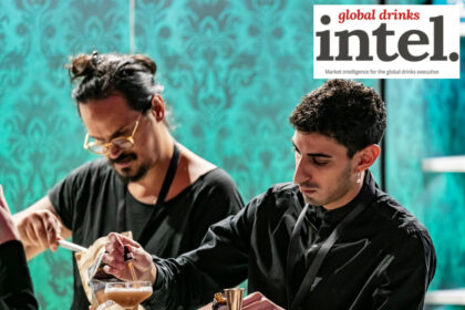 Two bartenders preparing cocktails behind a bar