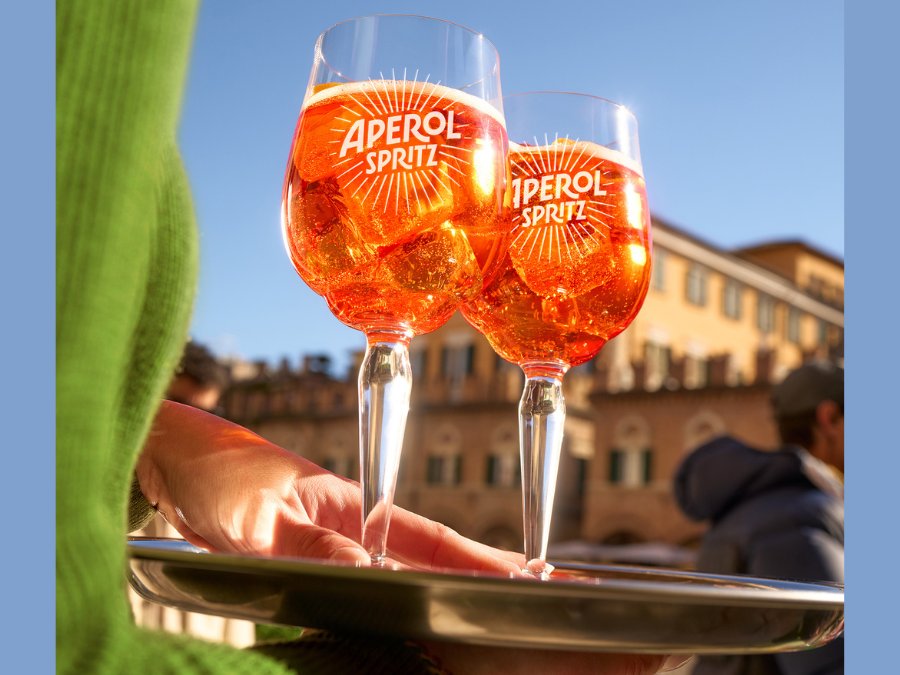 Two Aperol-branded glasses on a tray