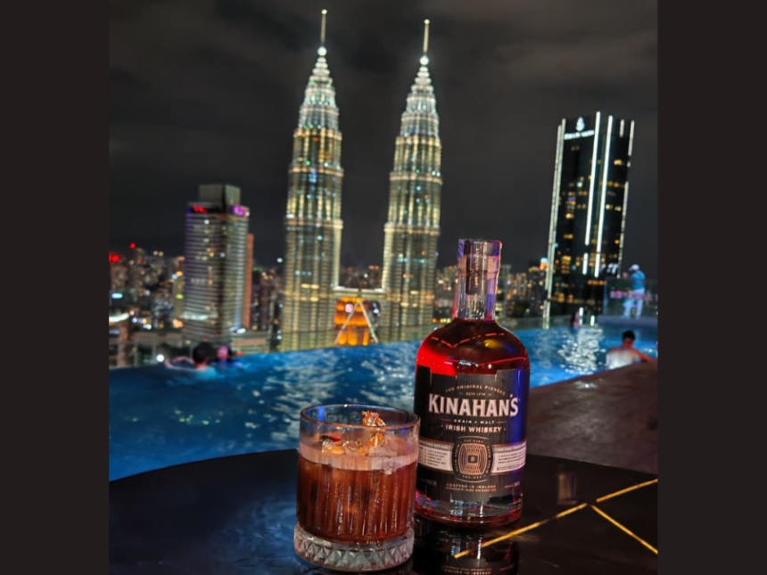 Kinahan's bottle with backdrop of Kuala Lumpur skyline at night