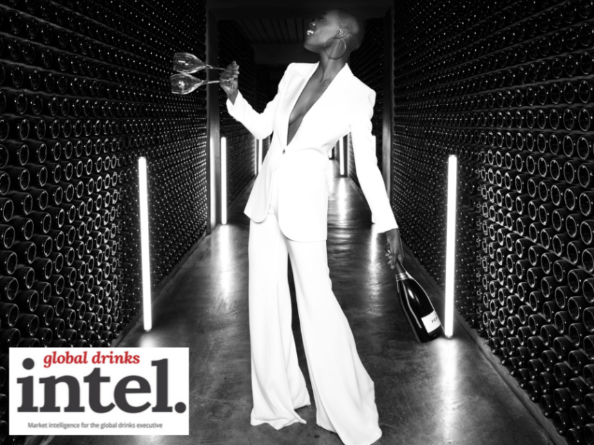Woman in a wine cellar holding two empty wine glasses and a bottle of Ferrari Trento