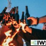 Younger drinkers outdoors with bottles of beer