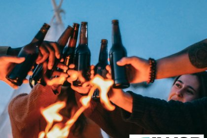 Younger drinkers outdoors with bottles of beer