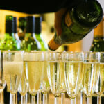 Glasses of Champagne next to a bottle of indeterminate brand