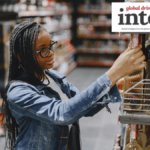 Woman in shop looking at bottles of alcohol