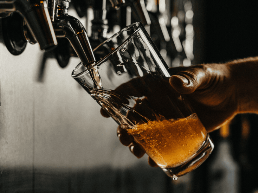 A pint of beer being poured in a pub