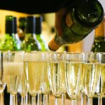 Glasses of Champagne next to a bottle of indeterminate brand