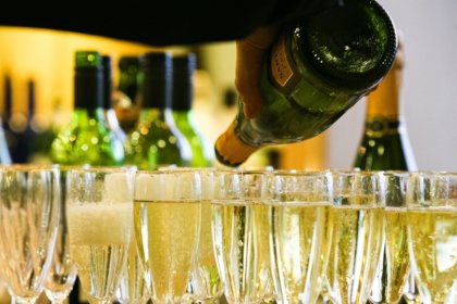 Glasses of Champagne next to a bottle of indeterminate brand