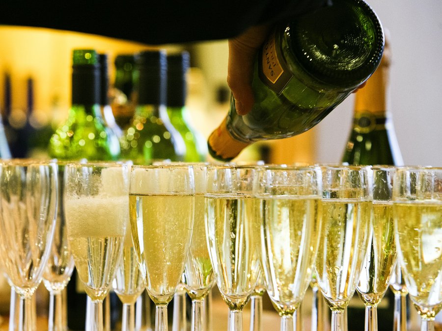 Glasses of Champagne next to a bottle of indeterminate brand