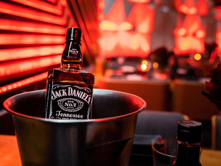 A bottle of Jack Daniel's in an ice bucket on a bar