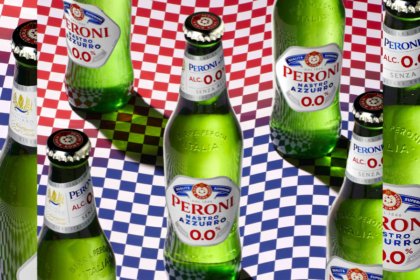 Bottles of Peroni Nastro Azzurro 0.0% against a chequered flag backdrop