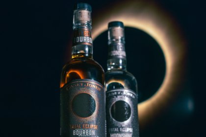 Bottle of Total Eclipse Bourbon next to Total Eclipse Moonshine
