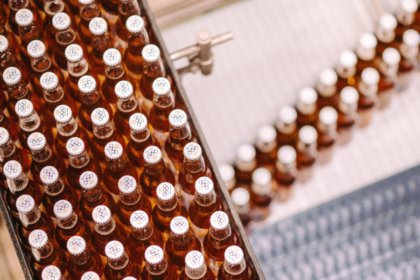 Bottles of Corona Cero on a production line displaying the Olympic Games rings on their caps