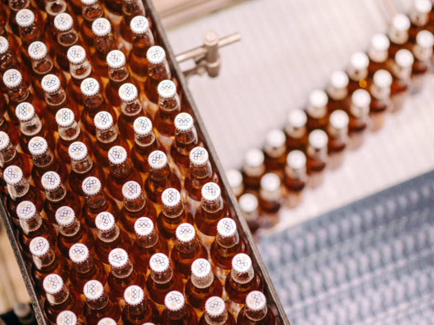 Bottles of Corona Cero on a production line displaying the Olympic Games rings on their caps