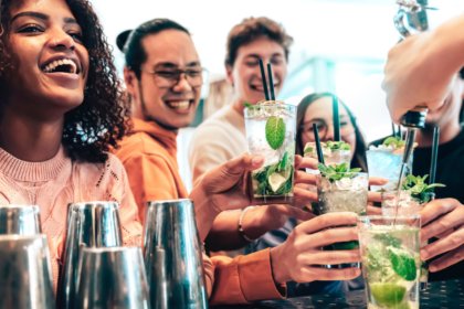 Drinkers raising glasses in a US bar