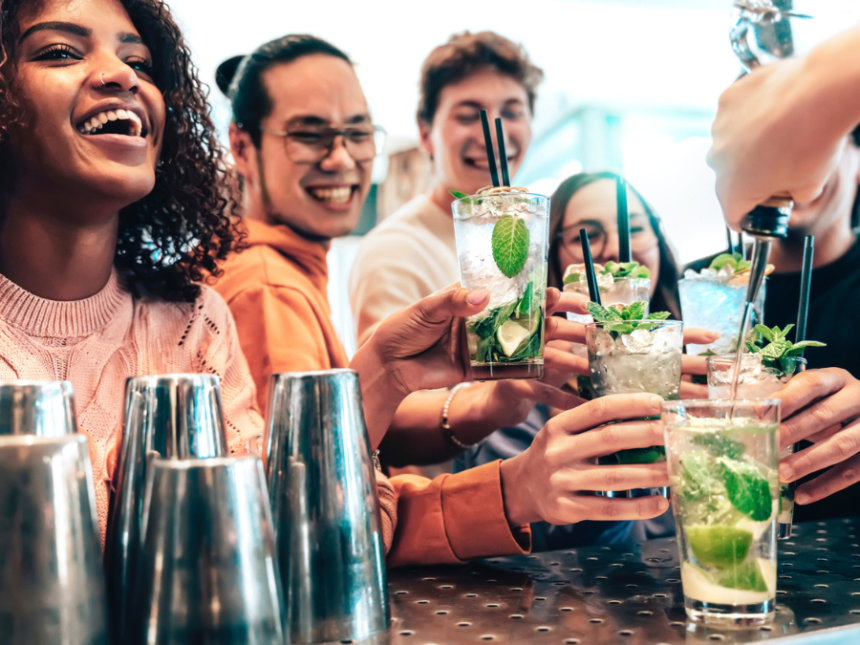 Drinkers raising glasses in a US bar