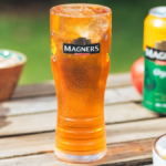 A branded glass and can of Magners