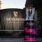 The English Premier League trophy in front of a Guinness-branded gate