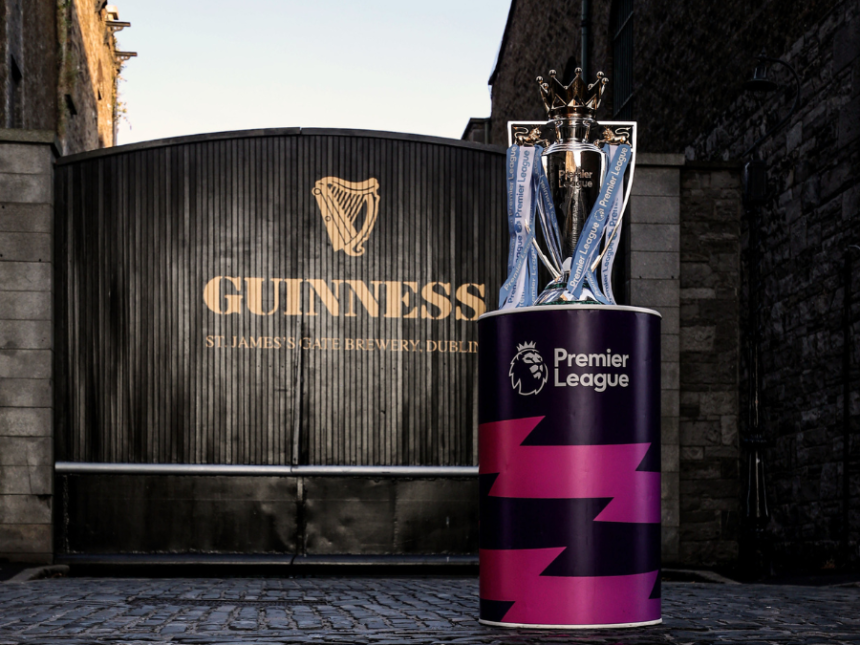 The English Premier League trophy in front of a Guinness-branded gate