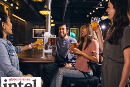 Four drinkers sitting at a bar