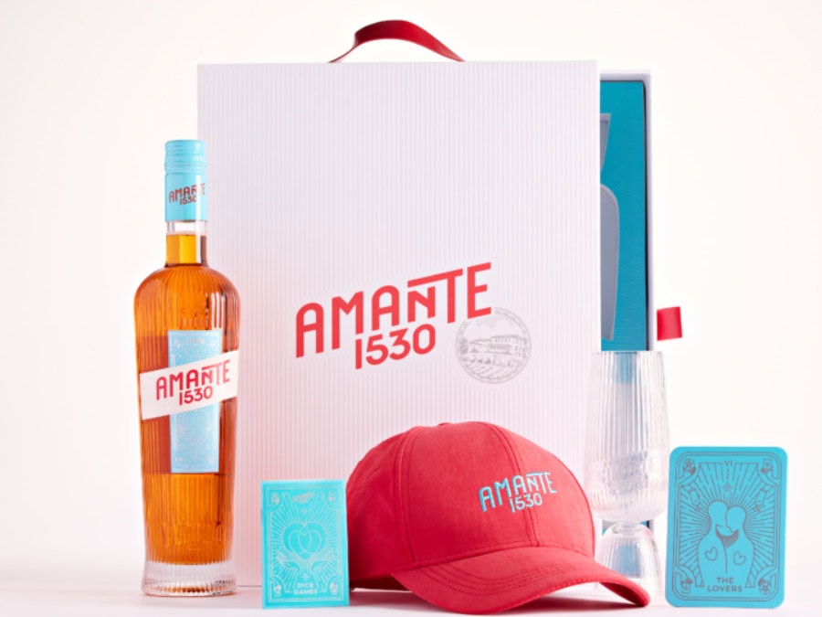 Bottle of Amante 1530 with a hat, a glass and some playing cards