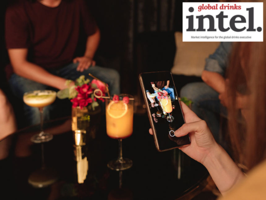 A drinker taking a photo of a cocktail on a smartphone
