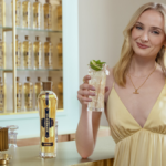 Sophie Turner at a bar with a bottle of St-Germain liqueur