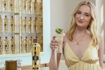 Sophie Turner at a bar with a bottle of St-Germain liqueur