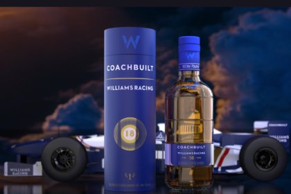 Bottle of and box for Coachbuilt 18-Year-Old Blended Scotch Whisky in front of a Williams F1 race car