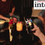 A drinker taking a photo of a cocktail on a smartphone