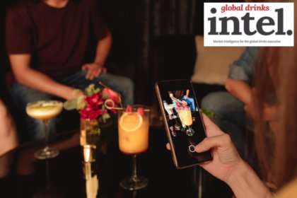 A drinker taking a photo of a cocktail on a smartphone