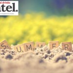 The word 'summer spelled out in Scrabble tiles on a sandy beach