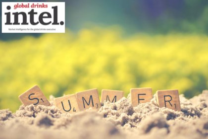 The word 'summer spelled out in Scrabble tiles on a sandy beach