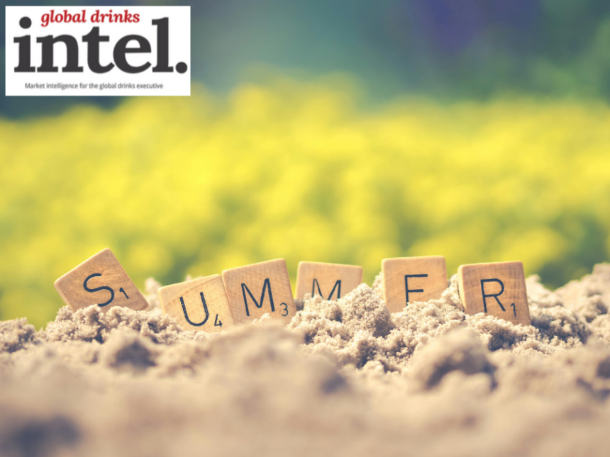The word 'summer spelled out in Scrabble tiles on a sandy beach
