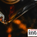 Close-up of a bottle of brown spirits being poured into a glass