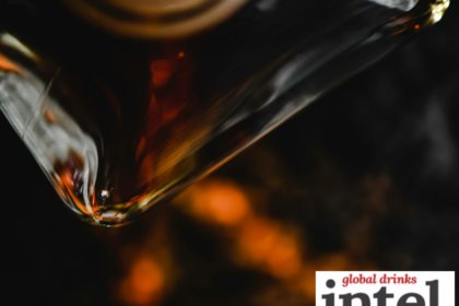 Close-up of a bottle of brown spirits being poured into a glass