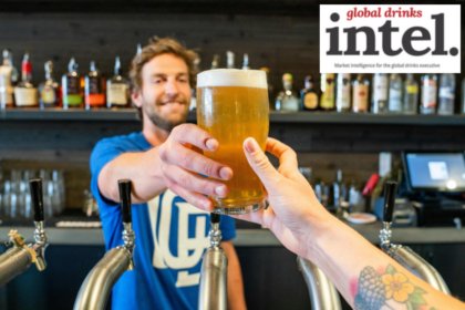 Bartender handing a drinker a full beer in a bar