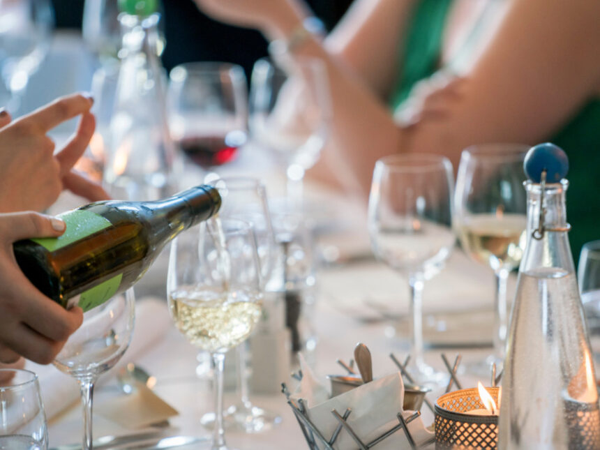 Wine being poured into a glass on a table