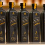 Line of five paper-based bottles of Johnnie Walker