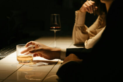 Person in a suit at a bar with an aged spirit in a glass